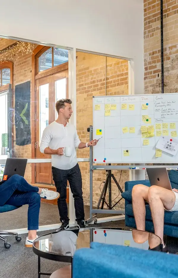 Team presenting a plan at a whiteboard